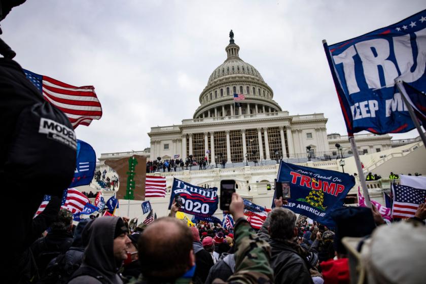 一群人站在人群面前：1月6日在国会大厦举行的亲特朗普暴民。