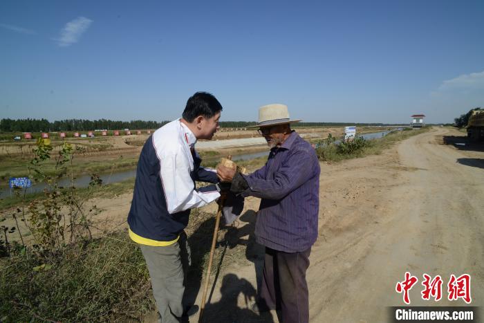 杨勇在走访时与当地人交流。(资料图)杨勇 供图